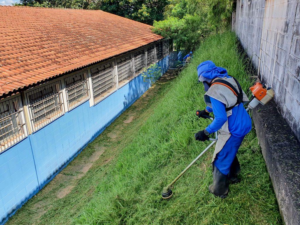 Funcionário realizando serviço de roçada em escola (Foto/Reprodução)