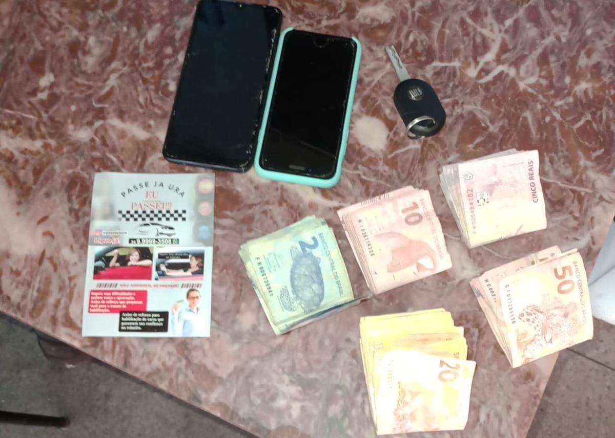 Dinheiro, celulares e panfleto anunciando os serviços clandestinos de autoescola apreendidos pela Polícia Civil e Guarda Municipal (Foto/Divulgação)