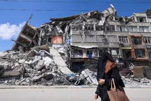 Palestina caminha diante de escombros de edifício na Cidade de Gaza (Foto/EMMANUEL DUNAND/AFP)