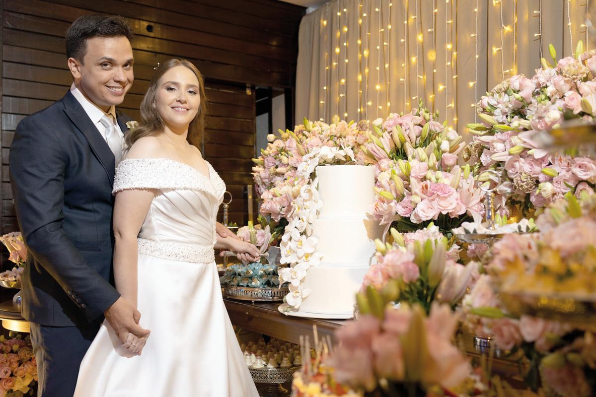 Isa Beatriz Carminatti e Guilherme Rodrigues, noivos do último fim de semana junto à mesa de doces e bolo na recepção (Foto/Alex Pacheco)