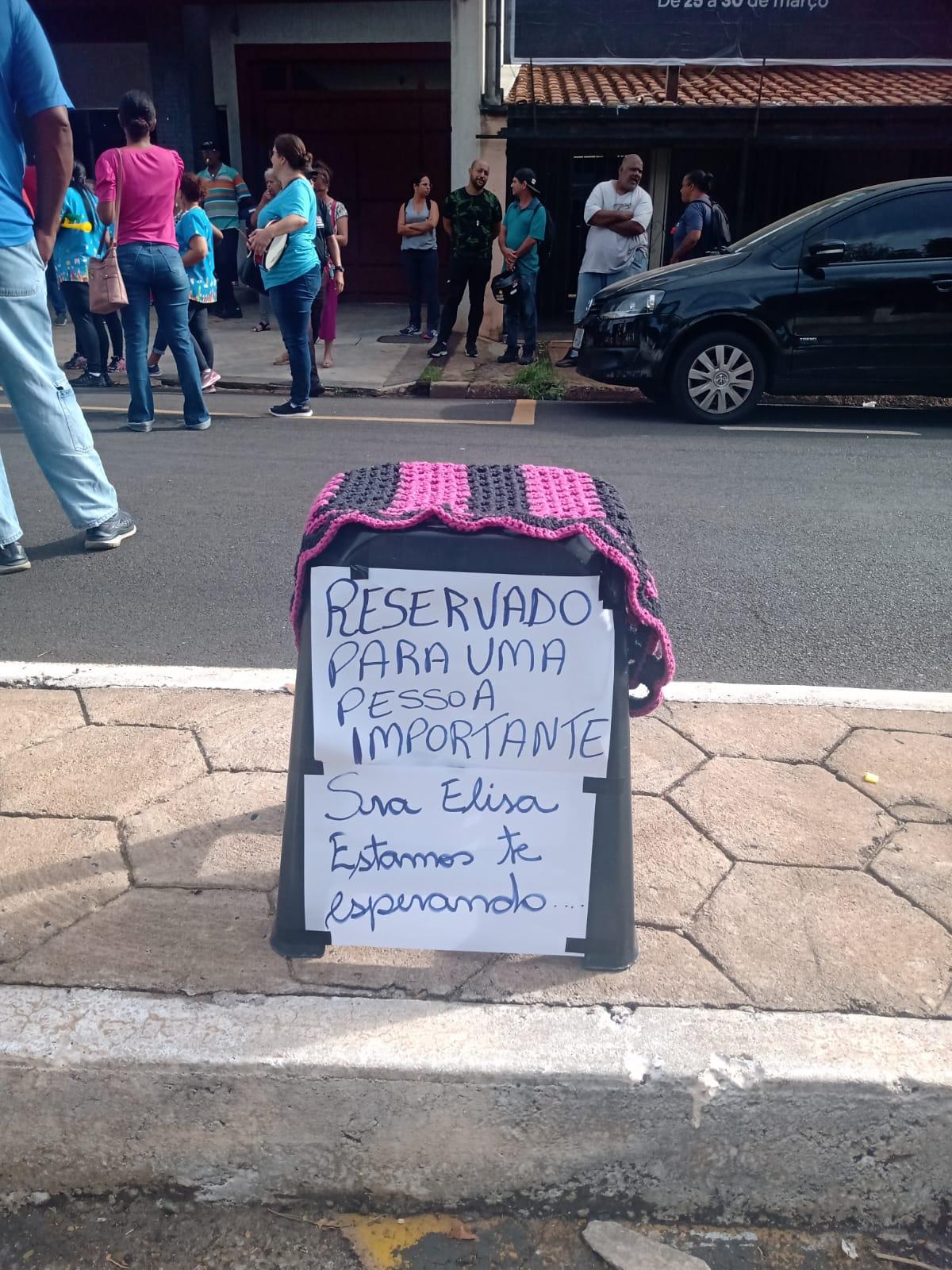 Na manifestação de quinta-feira (21), servidores em greve colocaram banco com cartaz chamando a prefeita para negociação com a categoria (Foto/Divulgação)