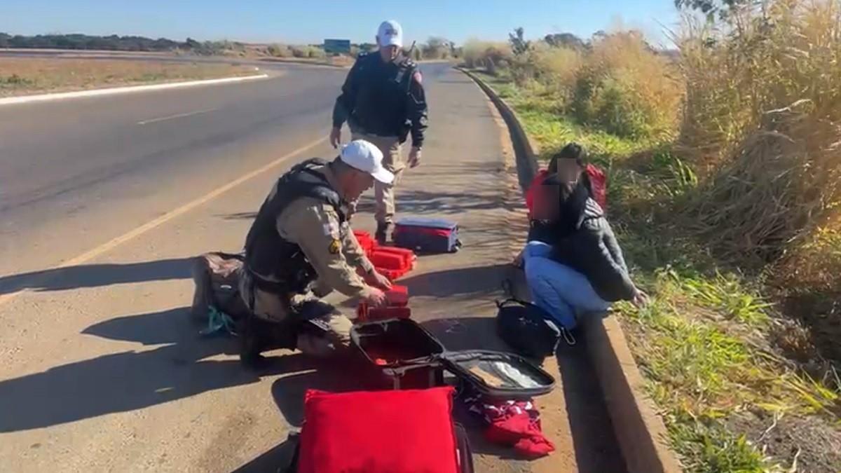 Mulheres estavam sentadas na beira da rodovia com malas cheias de maconha (Foto/PMRV/DIVULGAÇÃO)