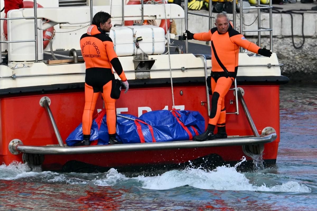 Imagem de autoridades italianas resgatam o corpo de uma das sete vítimas do naufrágio (Foto/Alberto PIZZOLI/AFP)