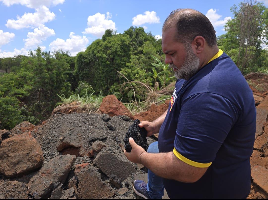 Túlio examina pedaço de bloco de asfalto e diz ser novo (Foto/Divulgação)