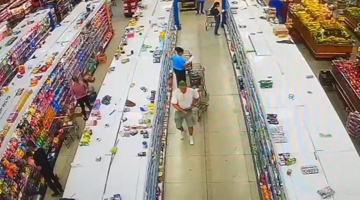 Câmeras de segurança do supermercado flagraram o momento em que o homem colocava as barras de chocolate no bolso e na cintura (Foto/Reprodução)