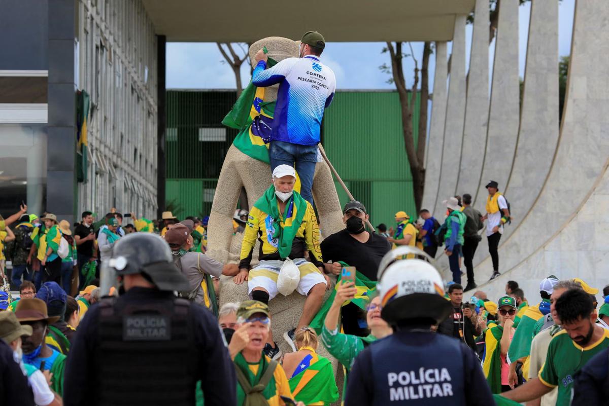 Policiais militares observam apoiadores do ex-presidente Jair Bolsonaro (PL) durante invasão e depredação da sede do Supremo Tribunal Federal (STF), em 8 de janeiro de 2023 (Foto/AFP or licensors)