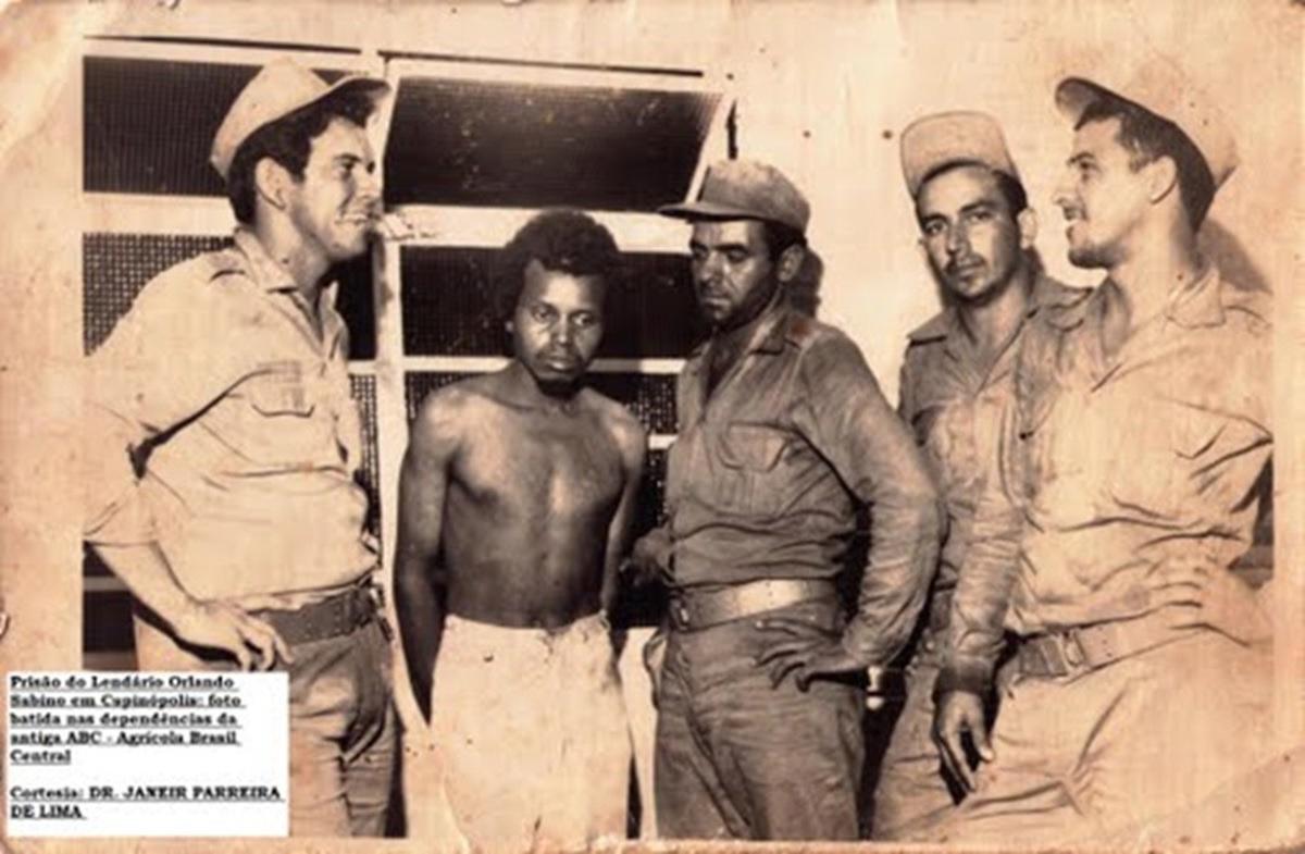 Fotografia retirada do jornal Tudo em Dia, reproduzida em 2011, mostra Orlando Sabino capturado por policiais (Foto/Reprodução/Jornal Tudo em Dia de 2011)