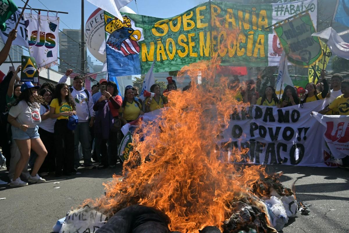 Manifestantes queimam bonecos de Donald Trump e Jair Bolsonaro, em frente ao consulado norte-americano, na zona sul de São Paulo, em protesto contra tarifaço e pela soberania brasileira (Foto/AFP or licensors)