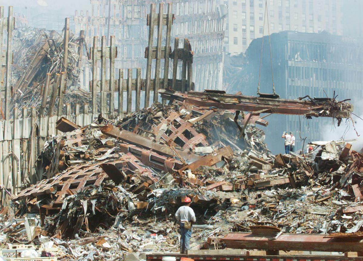 Equipes buscam sobreviventes em meio aos escombros após a colisão dos aviões com os edifícios (Foto/AFP PHOTO POOL/Mike Segar)