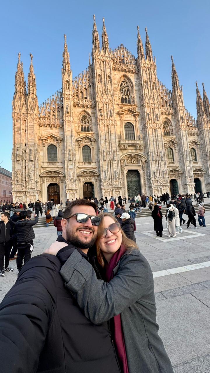 O jovem casal Alessa e Guilherme Ribeiro em suas Bodas de Papel, desfrutando de férias na Europa e posando com a imponente Catedral de Milão. (Foto/Reprodução)