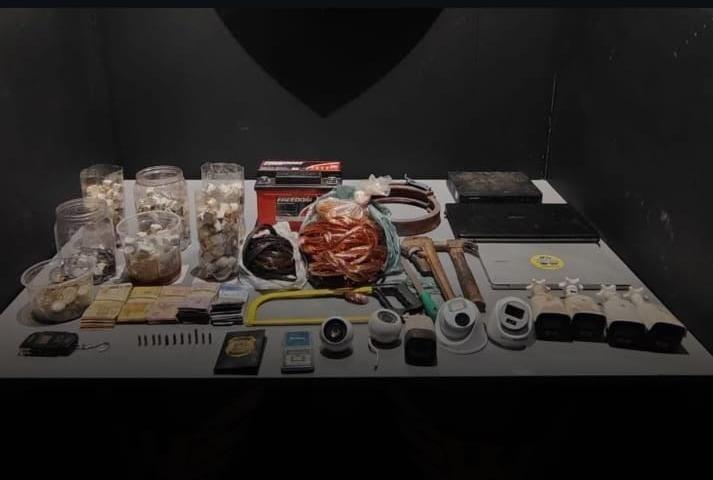 Tabletes e buchas de maconha, balança de precisão, celulares, dinheiro e materiais usados no fracionamento de entorpecentes foram apreendidos no bairro Gameleiras (Foto/Divulgação PMMG)